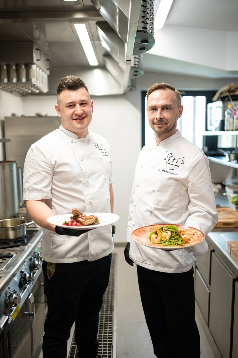 Sesja w kuchni restauracji — dwóch kucharzy z gotowymi daniami