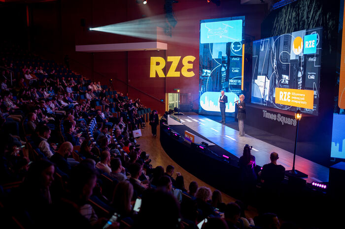 Konferencja — scena z ekranami i publiczność na sali